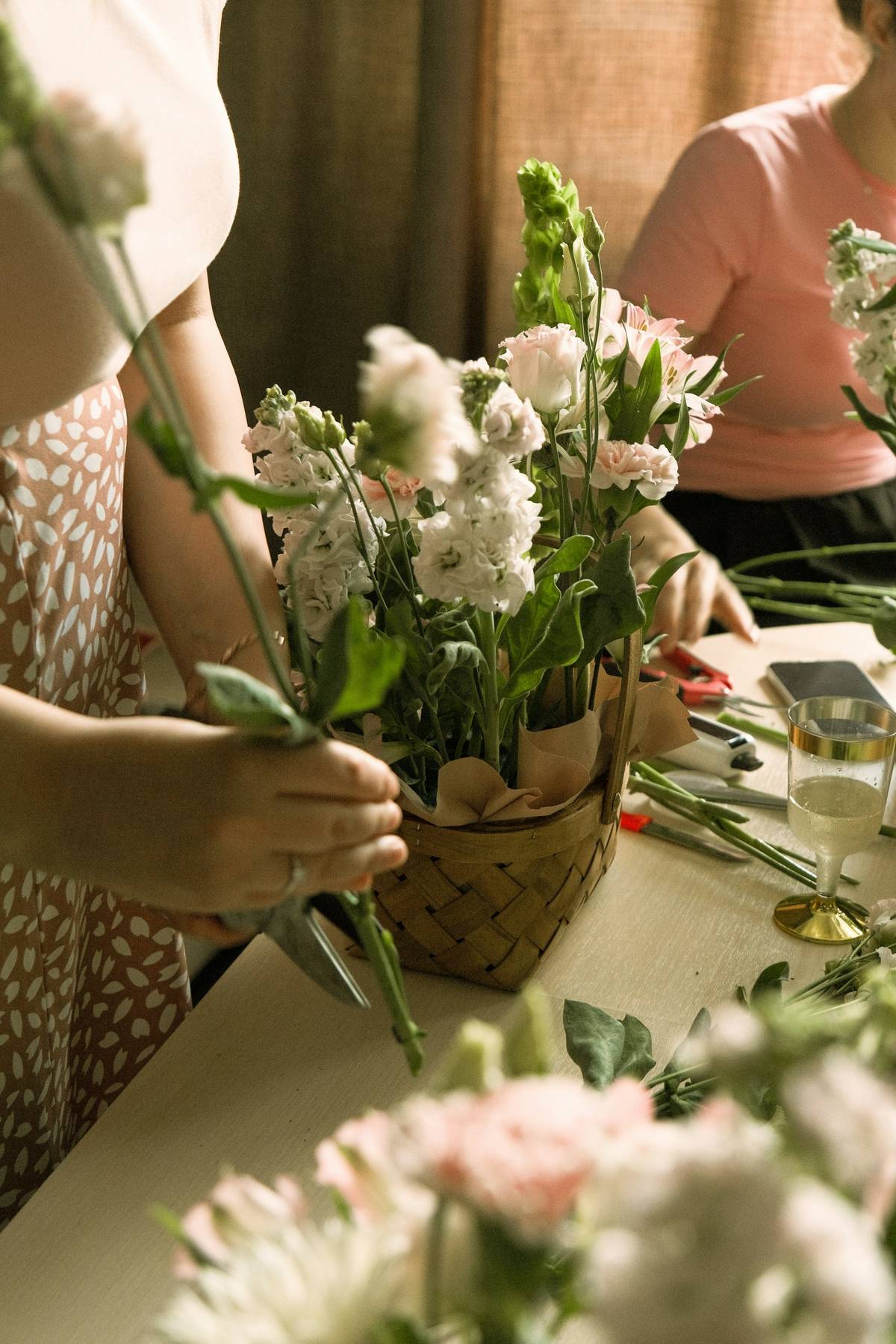 White and blush stems being gathered into a bouquet on a workbench