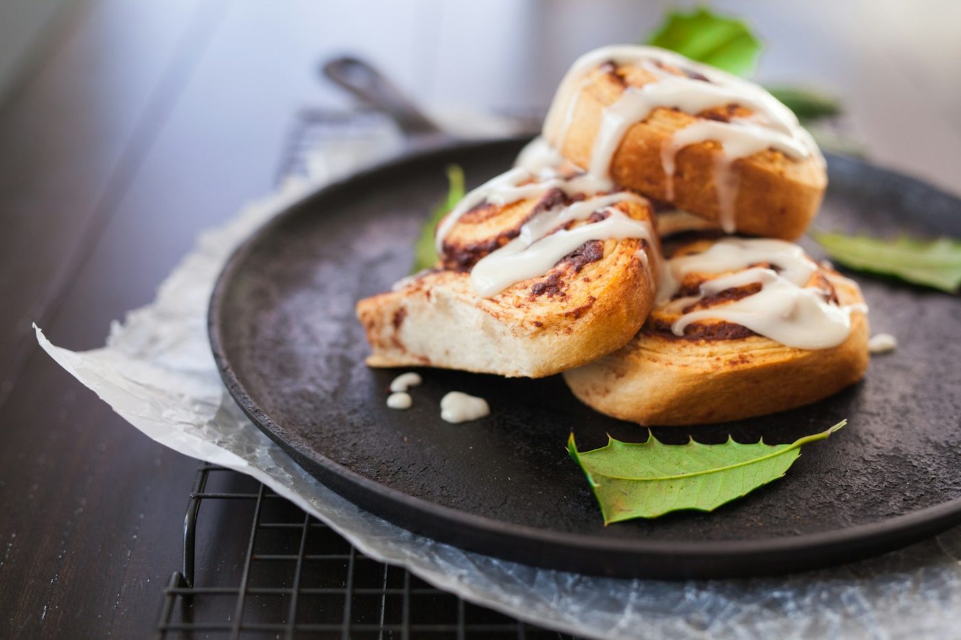 Iced cinnamon buns on a dark pan